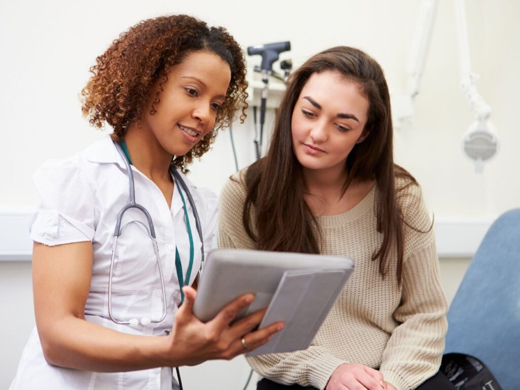 a woman looking at her medical chart held by her optometrist
